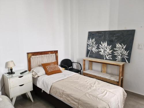 a bedroom with two beds and a desk and a painting at Acogedora habitación para mujeres viajeras in Cordoba