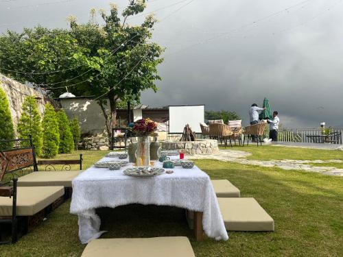 a table with a white table cloth on top of a yard at Peace Stay 2BHK Villa in Bhīm Tāl