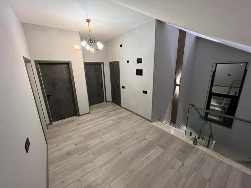 an empty room with a wooden floor and a hallway at VM Villa in Baku