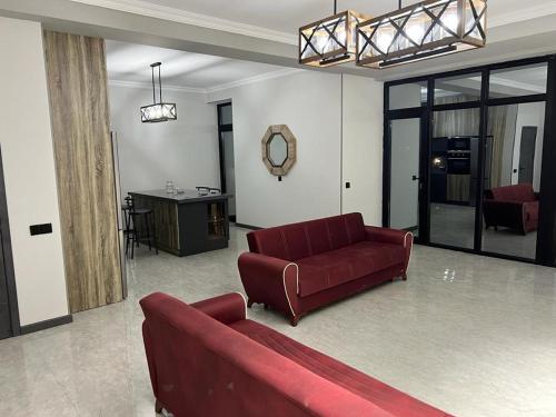 a living room with a red couch and a table at VM Villa in Baku