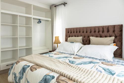 a bedroom with a large bed with a large headboard at 2-Bed Cottage in Mount Pleasant, Harare in Harare