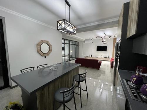 a kitchen and living room with a counter and chairs at VM Villa in Baku