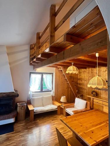 a living room with wooden walls and a wooden table at Wood & Fire Chalet in Borno