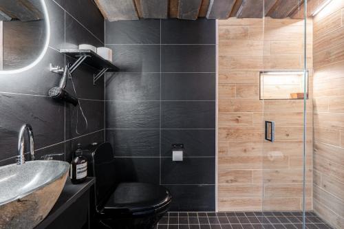 a bathroom with a black toilet and a glass shower at Koskisviitti 3 - Private Lakeside Suite with Terrace in Laukaa