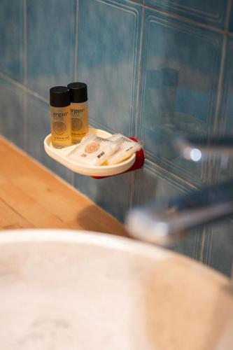 two bottles of medicine on a shelf in a bathroom at LE NEPTUNE - Vue Mer - Grande terrasse - Parking Privé in Menton
