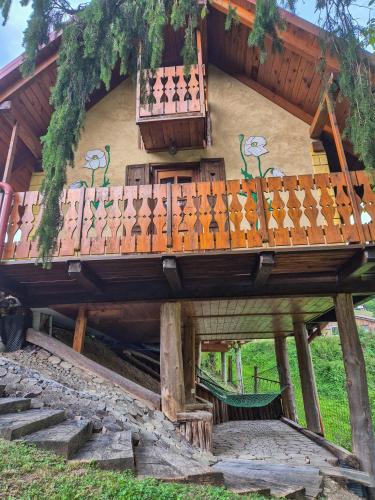 a wooden house with a balcony on top of it at Pastirski stan in Makole