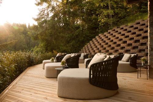 a row of couches sitting on a wooden deck at Domaine de Montagne - Hôtel Chalet Frère Joseph in Ventron