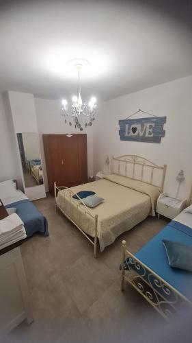 a bedroom with two beds and a chandelier at Tana della Lavanda in Montefiorino