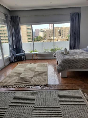 a bedroom with a bed and a large window at The Ultimate Luxury Stay at garden city in Cairo