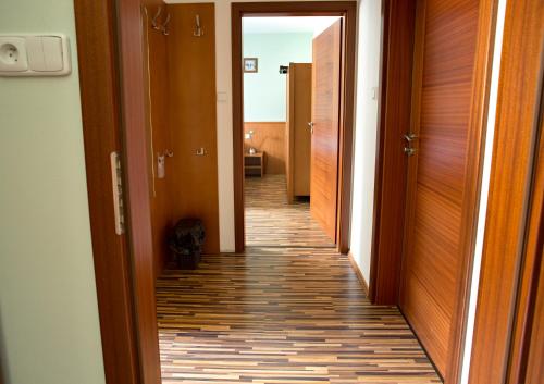 a hallway with wooden doors and a tile floor at Penzion Trojkámen in Nové Losiny