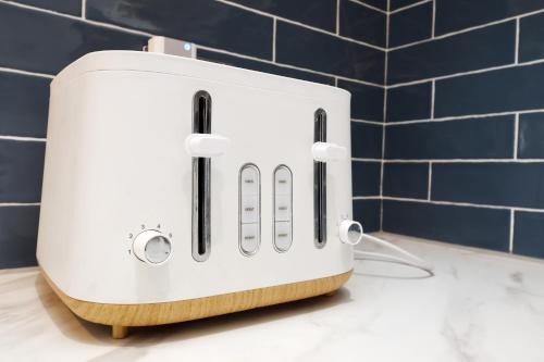 a white toaster sitting on top of a counter at Spacious 3 Bedroom Home in Heart Of Pontypool With Parking - By EKLIVING LUXE Short Lets & Serviced Accommodation in Griffithstown