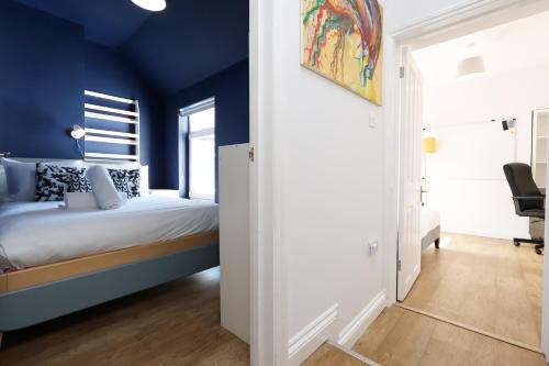 a bedroom with blue walls and a bed at Spacious 3 Bedroom Home in Heart Of Pontypool With Parking - By EKLIVING LUXE Short Lets & Serviced Accommodation in Griffithstown