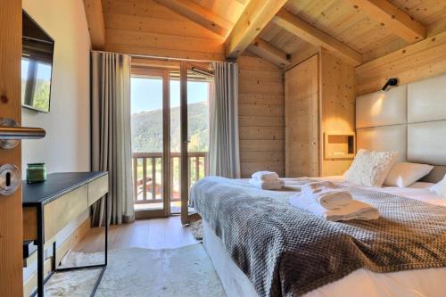 une chambre avec un lit avec un bureau et une fenêtre dans l'établissement Résidence Goya - Chalet Goya - 10 Personnes - Les Gets MAE-0113, à Cohennoz