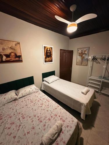 a bedroom with two beds and a ceiling fan at cantinho da padroeira in Aparecida