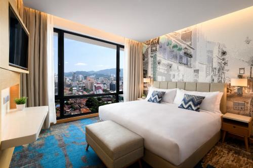 a bedroom with a large bed and a large window at OZO George Town Penang in George Town