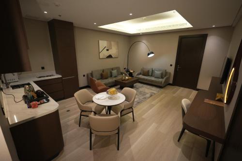 a kitchen and a living room with a table and chairs at Snood Al Narjis Hotel in Riyadh