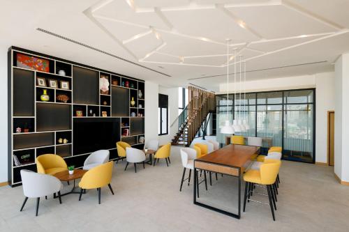 a dining room with a table and yellow chairs at OZO George Town Penang in George Town