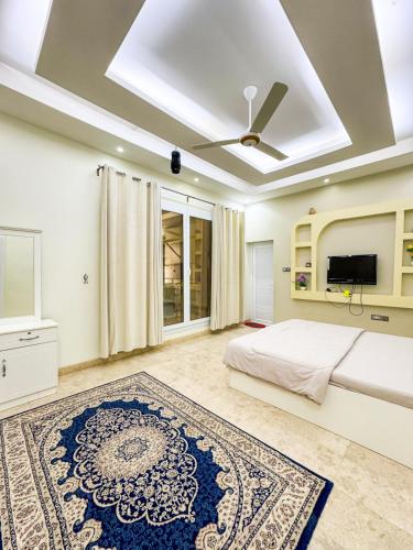 Un dormitorio con una cama y un ventilador de techo. en أستراحة الرأسيات, en Al Khawḑ