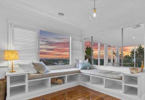 a white room with windows and a bench with a view at 'Bellevue Manor' on Beauty Point in Wagga Wagga