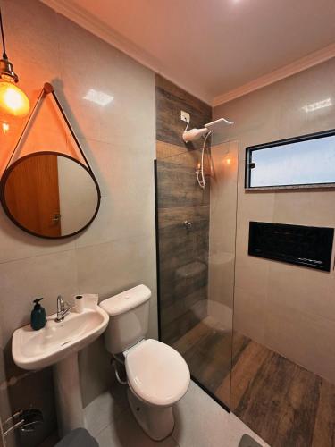 a bathroom with a toilet and a sink and a shower at cantinho da padroeira in Aparecida
