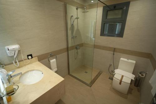 a bathroom with a sink and a shower and a toilet at Snood Al Narjis Hotel in Riyadh