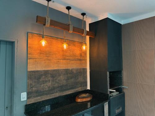 a kitchen with a counter with lights on it at cantinho da padroeira in Aparecida
