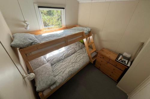 two bunk beds in a small room with a window at Gullingen Cabin Winter Wonderland 
