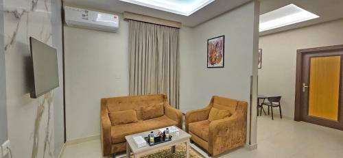 a living room with two chairs and a table at افاق سويت للشقق المخدومة السلي in Riyadh