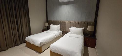 a hotel room with two beds and a mirror at افاق سويت للشقق المخدومة السلي in Riyadh