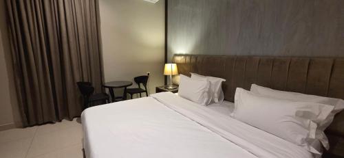 a bedroom with a large bed with white sheets and pillows at افاق سويت للشقق المخدومة السلي in Riyadh
