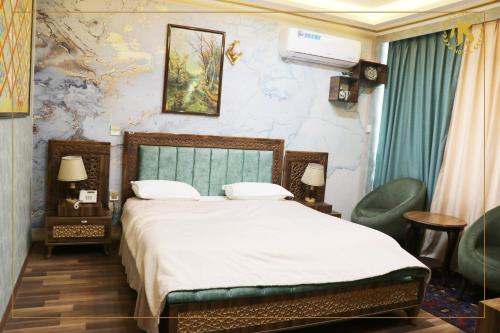 a bedroom with a bed and two chairs at Hotel Intercontinental Kabul in Kabul