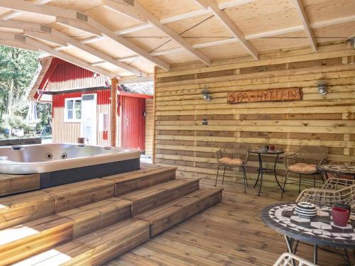 a soaking tub in a wooden patio with a table and chairs at 4 star holiday home in Blåvand in Blåvand