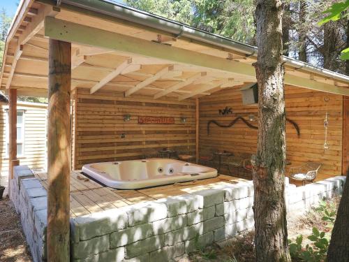 a large bath tub sitting under a wooden cabin at 4 star holiday home in Blåvand in Blåvand