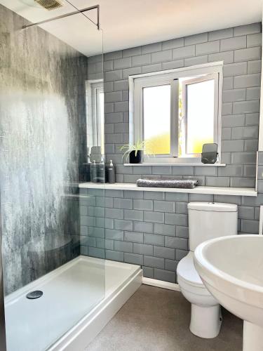 a bathroom with a tub and a toilet and a sink at Finest Retreats - Porth Cottage in Newquay