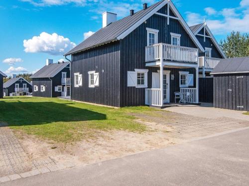a large black house with a gambrel roof at 8 person holiday home in Gjern in Gjern