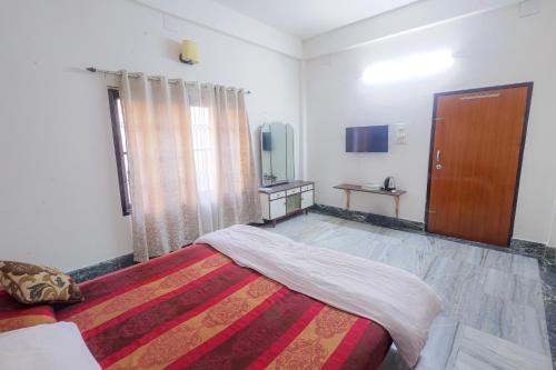 a bedroom with a bed and a window and a door at Bhaskar Homestay - The Bungalow in Dibrugarh