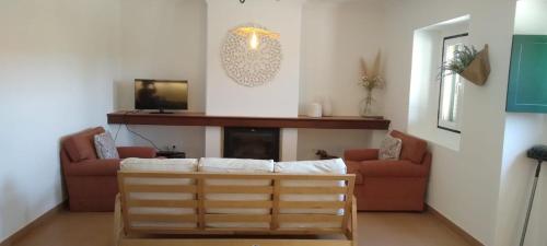 a living room with a couch and a fireplace at Herdade do Gamito in Crato