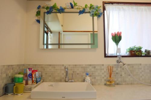 a bathroom counter with a sink and a mirror at 立花荘 in Matsuyama