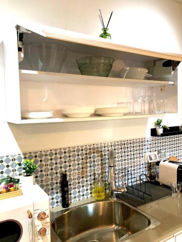 a kitchen counter with a sink and a microwave at Authentic apartments with jacuzzi and Two-level central Haifa in Haifa