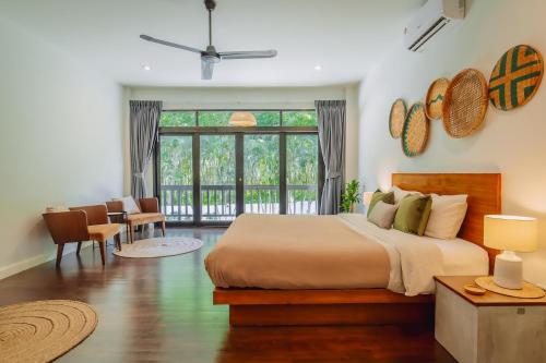 a bedroom with a bed and a large window at Eden Villa A Tropical Paradise Pool Villa in Rawai Beach