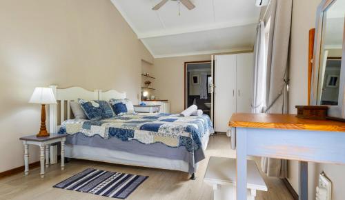 a bedroom with a bed with a blue and white comforter at Emerald Cove in Shelly Beach