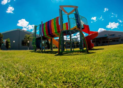 a playground with a slide on a grass field at Hotel Nacional Inn São Carlos & Convenções in São Carlos