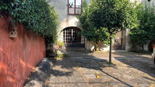 a tree next to a building with a red wall at Residenza in palazzo storico del 1601 in Airola