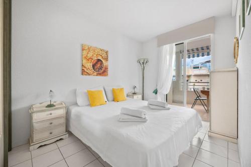 a bedroom with a white bed with yellow pillows at RIVIERA PRESTIGE - Front de Mer - Terrasse - Parking in Roquebrune-Cap-Martin