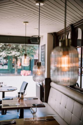 a restaurant with two tables and two chandeliers at Allerdale Court Hotel in Cockermouth