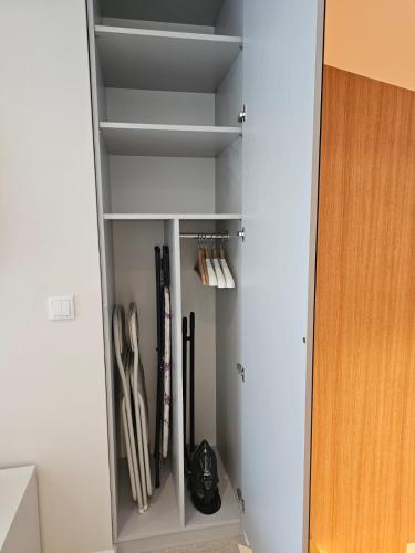 a white cabinet with some utensils in it at Sileo Apart No.85 in Ustka