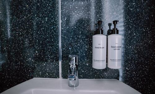 a bathroom sink with two bottles ofodorizers on it at Allerdale Court Hotel in Cockermouth