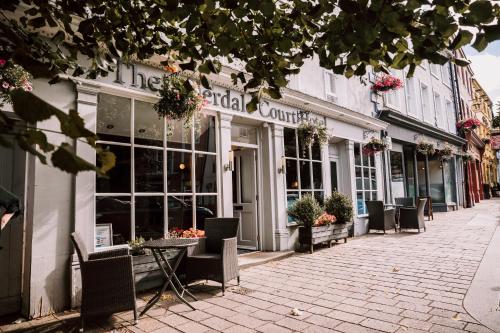 a street with tables and chairs in front of a store at Allerdale Court Hotel in Cockermouth