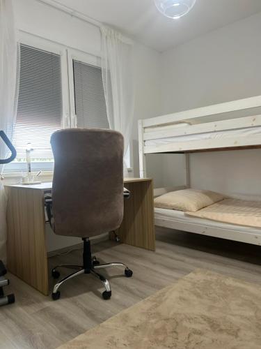 a desk and a chair in a room with two bunk beds at Wellness Way in Dunajská Streda