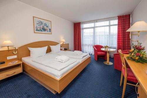 a hotel room with a bed and a desk at Johannesbad Hotel Königshof in Bad Füssing
